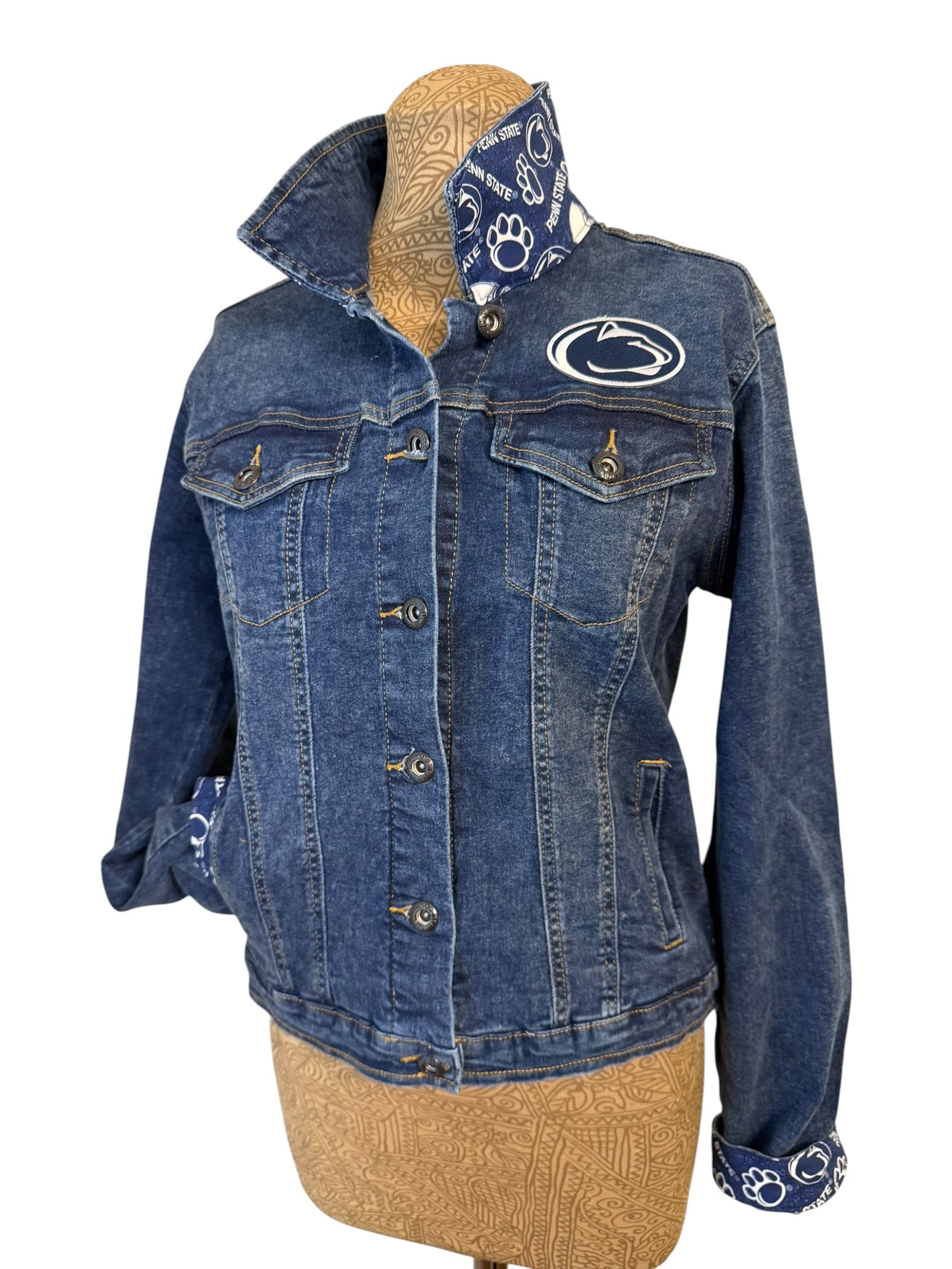 Blue denim jacket with a logo on a mannequin against a white background
