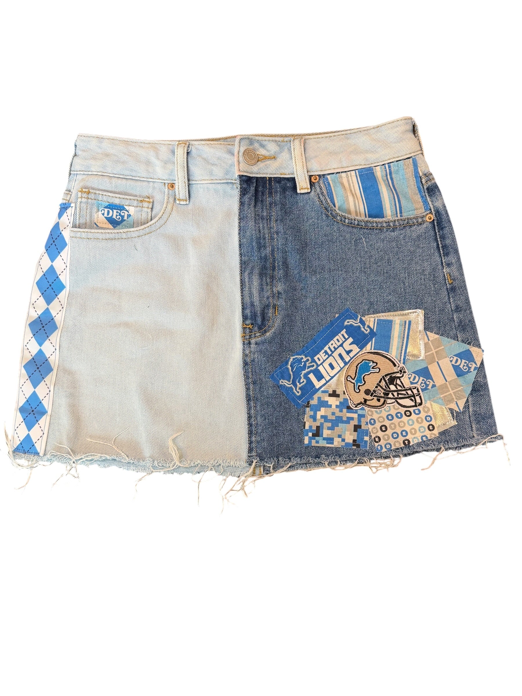A split-design denim mini skirt made from two different washes of jeans, featuring Detroit Lions themed patches and a blue-and-white argyle pattern on a white background.