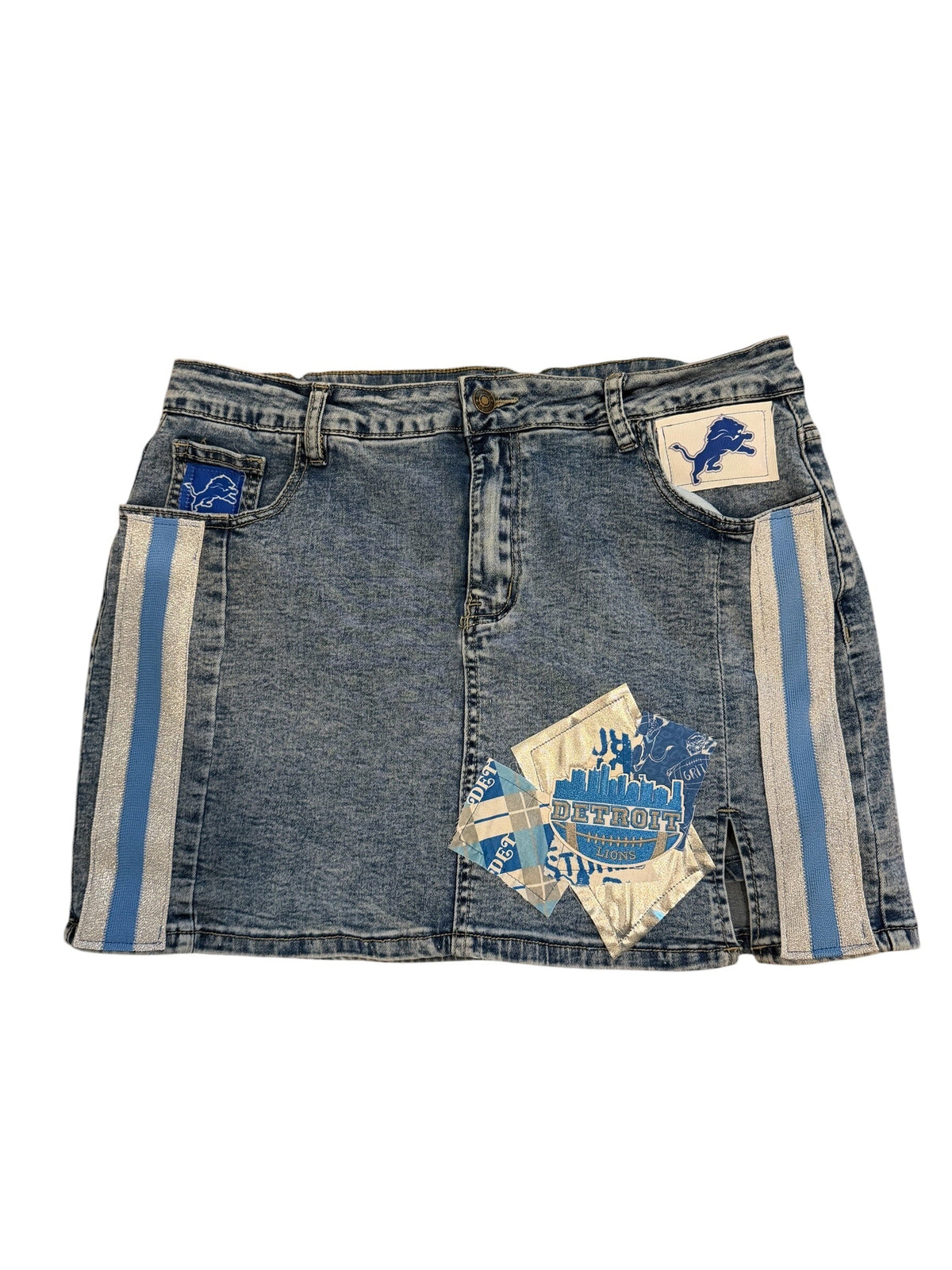 A pair of vintage blue denim shorts featuring light blue and white striped side panels, a blue graphic patch on the left leg, and a blue and white patterned patch on the right leg.