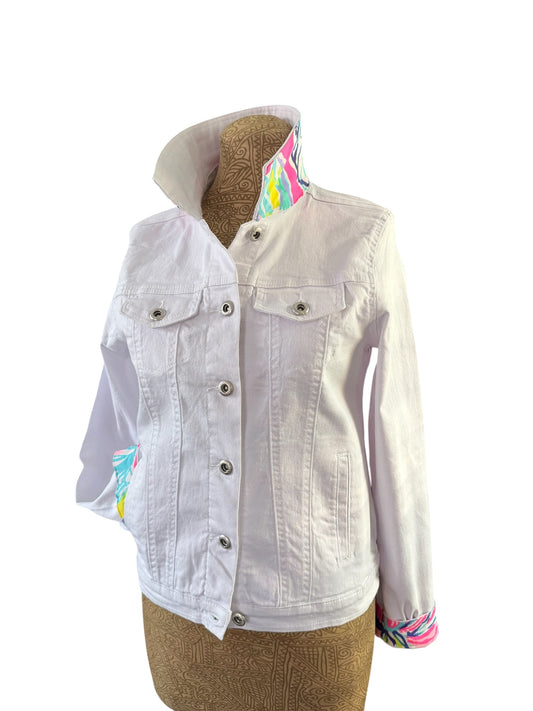 A white denim jacket with colorful patterned lining details on the collar and cuffs, displayed on a brown mannequin torso against a white background.