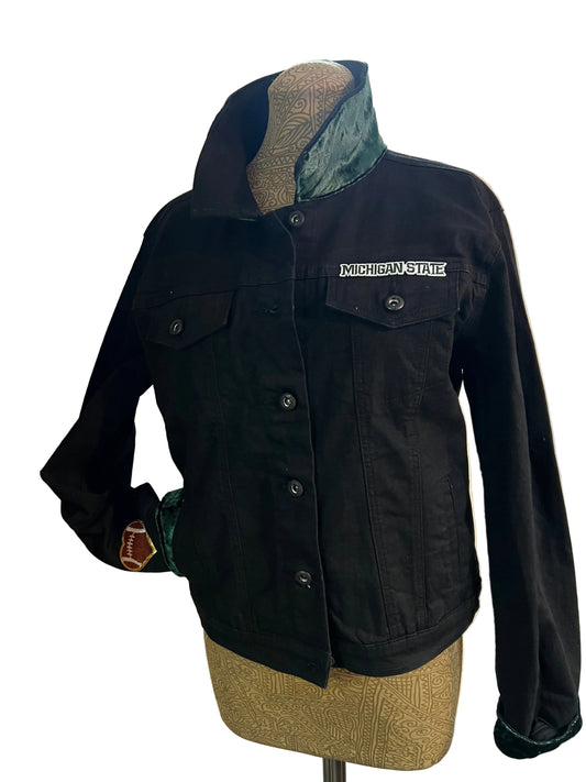 Black jacket with a brand logo on a light-colored surface