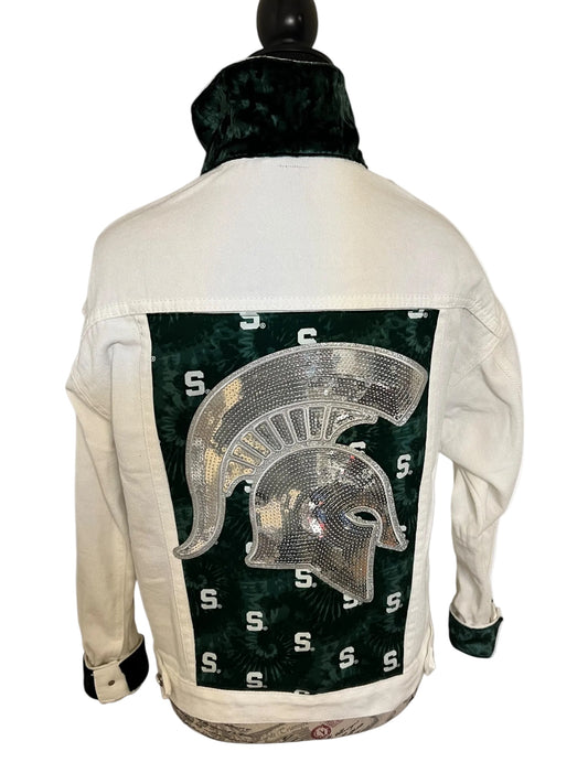 White denim jacket with a green and gold Spartan helmet design on the back